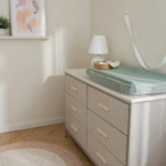 A tall fabric dresser secured with a wall-anchor strap in a child's room, illustrating tip-over prevention