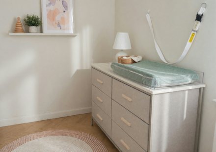 A tall fabric dresser secured with a wall-anchor strap in a child's room, illustrating tip-over prevention