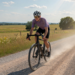 Gravel cyclist in helmet and eye protection on a dusty gravel road