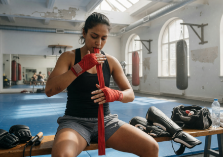 Martial artist wrapping hands with hand wraps in a bright training gym