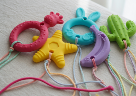 Assortment of colorful silicone baby teething toys with long dangling strings