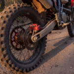 Off-road enduro dirt motorcycle on a trail with the rear brake caliper in focus