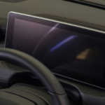 Dark, blank digital instrument cluster behind a car steering wheel, illustrating the Toyota Camry Hybrid recall