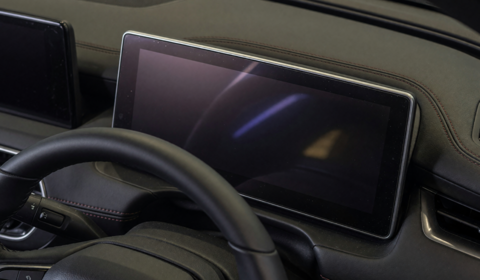 Dark, blank digital instrument cluster behind a car steering wheel, illustrating the Toyota Camry Hybrid recall