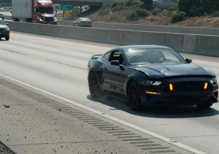 A Ford Mustang pulled onto a highway shoulder with hazard lights on after a power-loss issue
