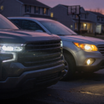 A pickup truck and SUV at dusk with one dim headlight and one bright, illustrating the Ford headlight recall visibility hazard